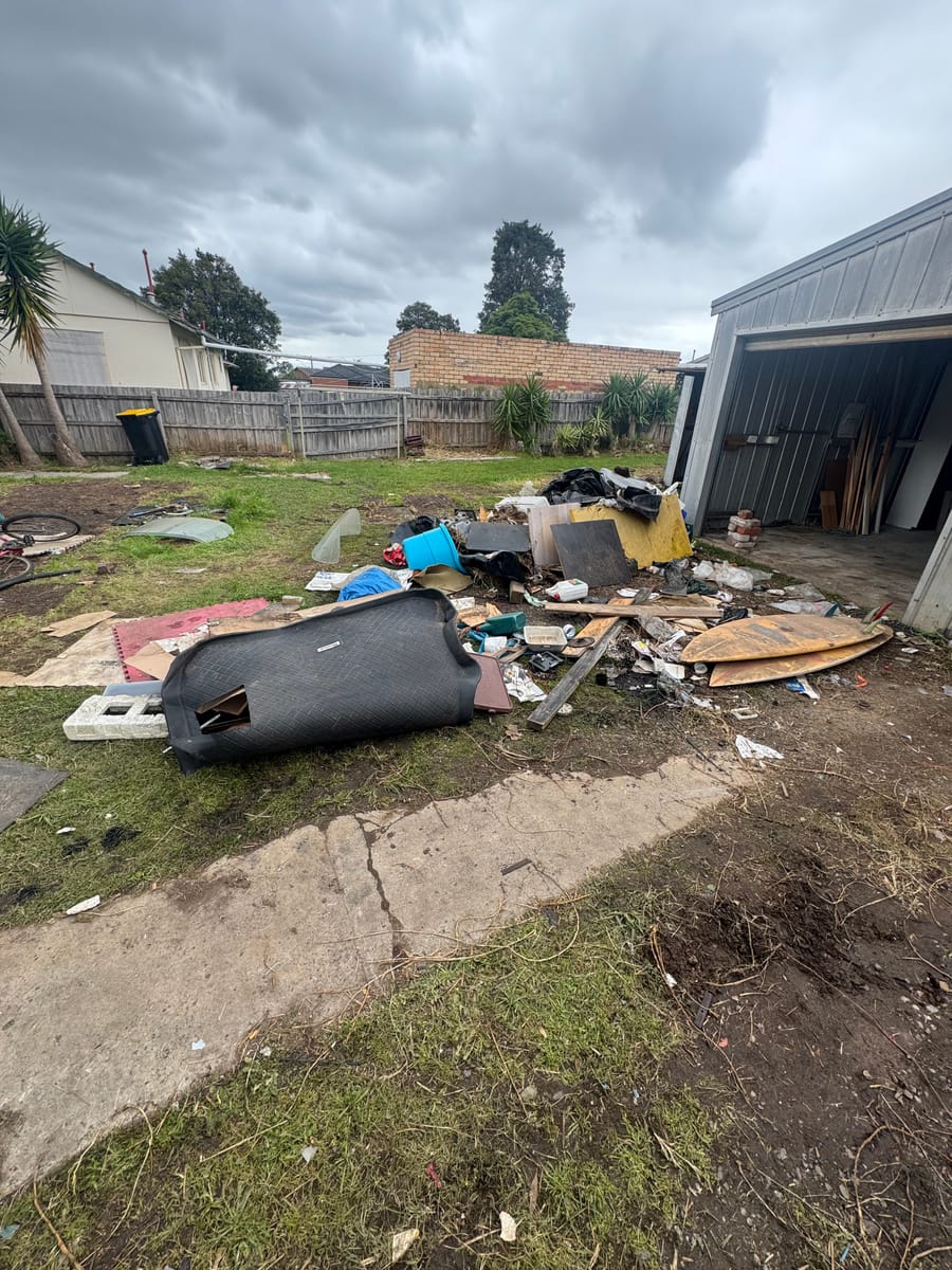 Backyard and shed area cluttered with junk before cleanout in Melbourne