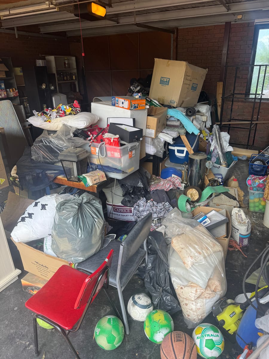 Garage full of junk and bins before a full garage cleanout in Melbourne