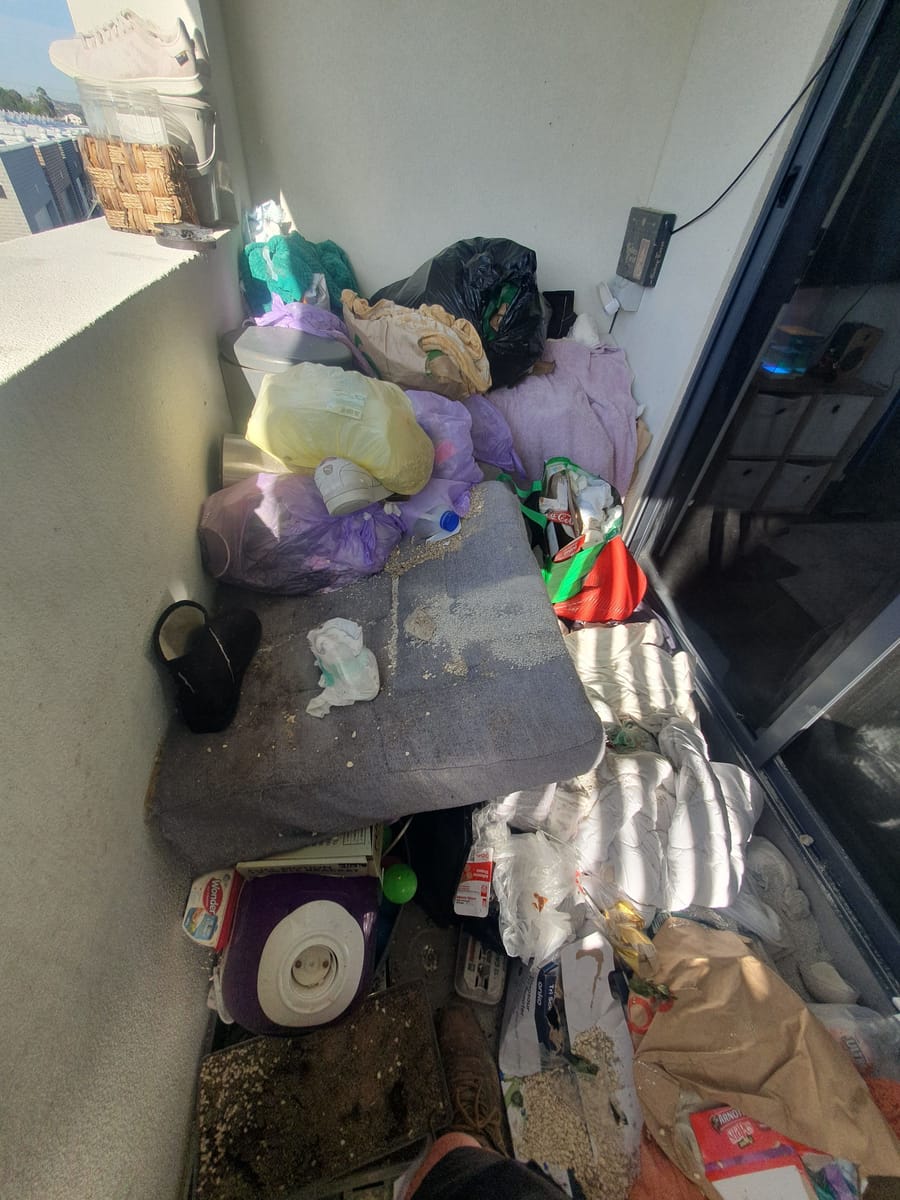Balcony piled with bags of household junk before rubbish removal in Melbourne