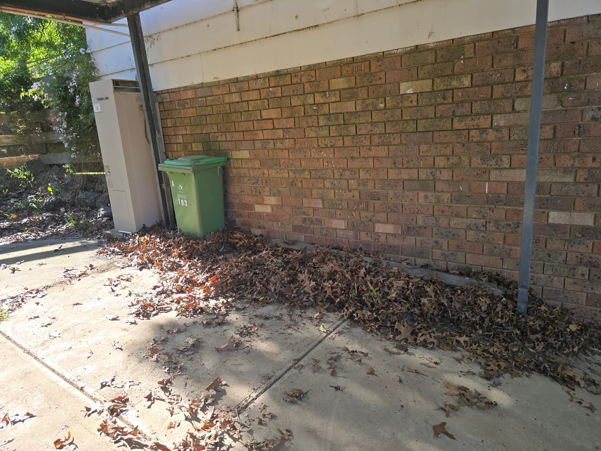 Cleared brick wall area with wheelie bin after household rubbish removal in Melbourne