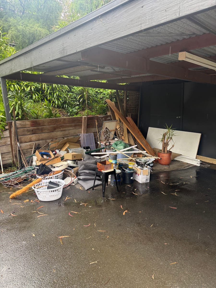 Pergola and carport piled with junk before a property cleanout in Melbourne