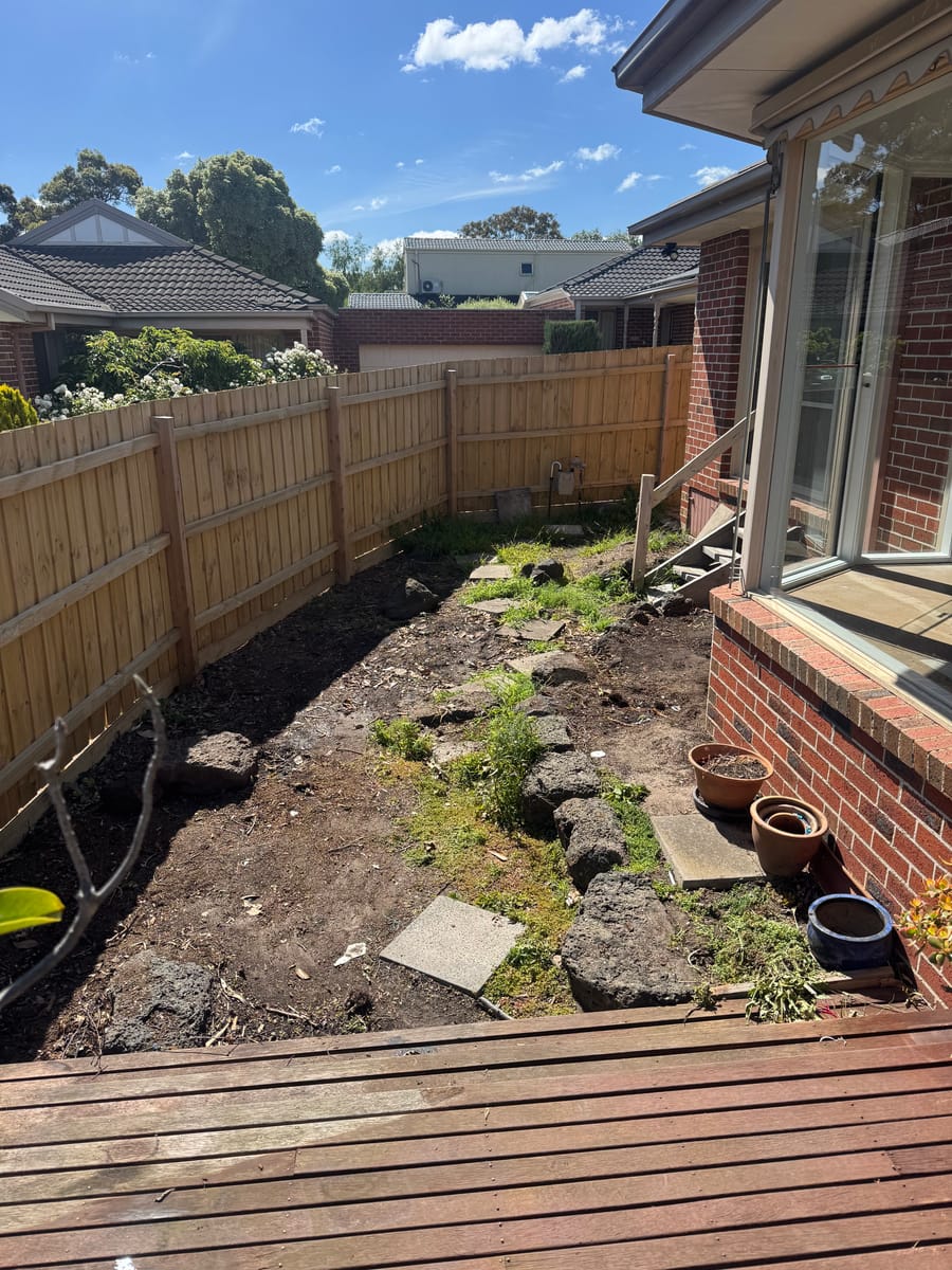 Cleared backyard with stacked timber after renovation waste removal in Melbourne